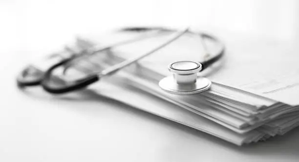 Photo of Stack of report medical documents and stethoscope isolated on white background