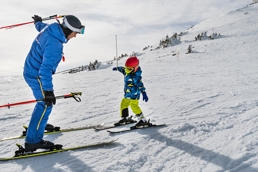 Happy family, enjoying ski holiday with children, sunny beautiful weather outdoors