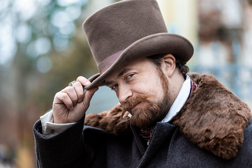 Respectable mustachioed man in classic retro clothes, coat and hat