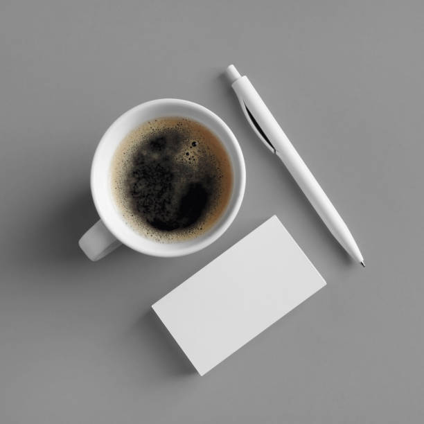 Business cards, coffee, pen Blank business cards, coffee cup and pen on gray paper background. Top view. Flat lay. square business card mockup stock pictures, royalty-free photos & images
