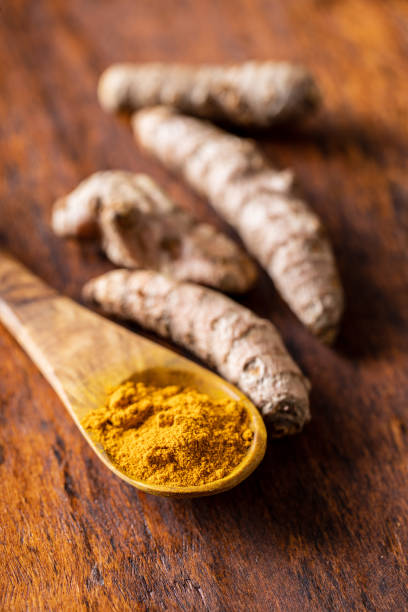 istock Indian turmeric powder and root. Turmeric spice. Ground turmeric 1302844999