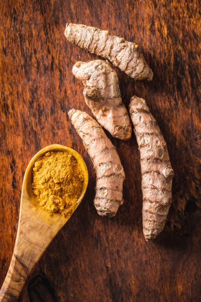 istock Indian turmeric powder and root. Turmeric spice. Ground turmeric 1302845003