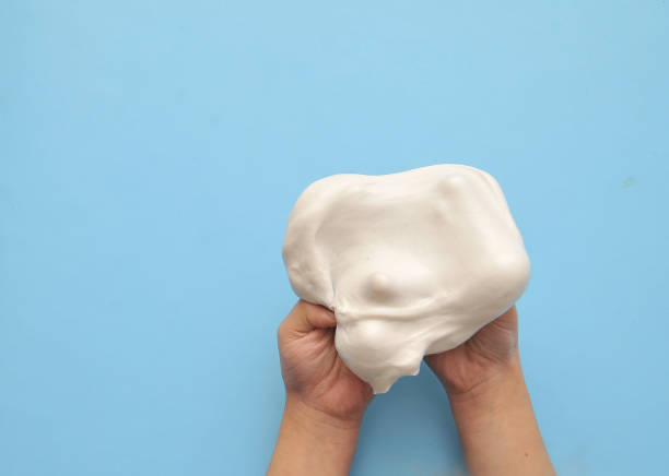 istock Child hands with slime on blue background. 1302852924