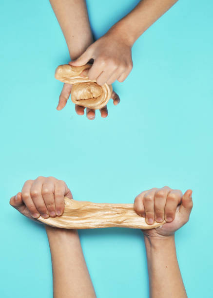 istock Child hands with slime on blue background. 1302852933