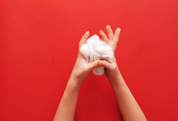 istock Child hands with slime on red background. 1302852994