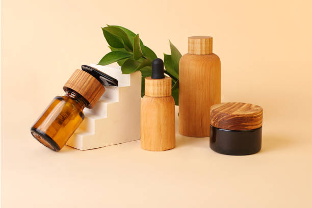 Eco-friendly tubes and bottles from the natural wood and brown glass near the geometrical pedestal.Fresh natural leafs on the background.Concept of the organic,zero waste cosmetics. Eco-friendly tubes and bottles from the natural wood and brown glass near the geometrical pedestal.Fresh natural leafs on the background.Concept of the organic,zero waste cosmetics. beauty product stock pictures, royalty-free photos & images
