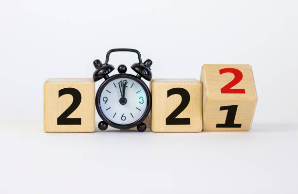 Business concept of 2022 new year. Turned a wooden cube and changed number 2021 to 2022. Black alarm clock. Beautiful white background, copy space. 2022 new year concept. Business concept of 2022 new year. Turned a wooden cube and changed number 2021 to 2022. Black alarm clock. Beautiful white background, copy space. 2022 new year concept. 2021 stock pictures, royalty-free photos & images