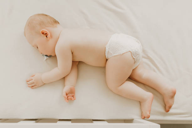 istock Sleeping little baby in a diaper sleeps in a crib 1302855633