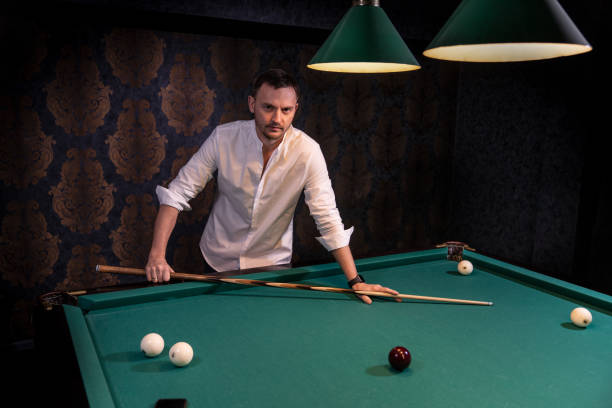 istock a man holding a billiard cue 1302857600