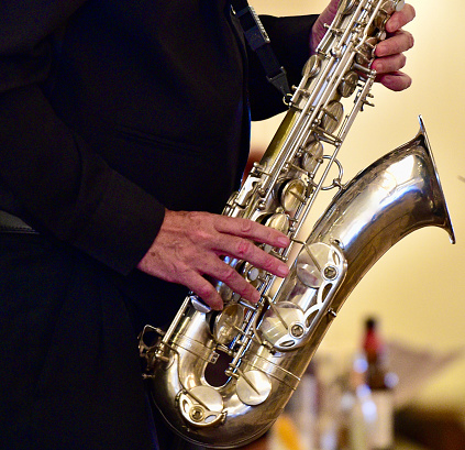 Tuba player with brass instrument. Hands playing euphonium. Wind instrument closeup