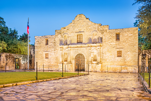 The Alamo illuminated at dawn in San Antonio Texas USA. The Alamo was founded in the 18th century as a Spanish Roman Catholic mission and today is part of the San Antonio Missions Unesco World Heritage Site.