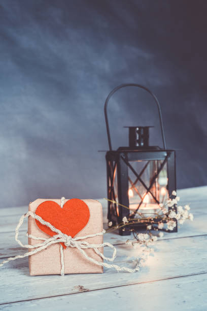 istock handmade gift with a red heart attached. an illuminated lantern in the background. eco friendly concept 1302866973
