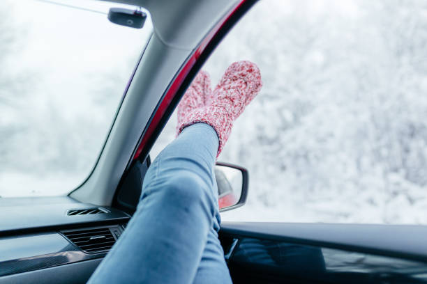 istock Young woman in warm socks resting inside car, close-up. 1302867866