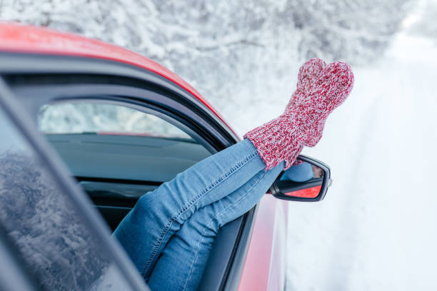 istock Close-up. Young woman in warm socks resting inside car. 1302867874