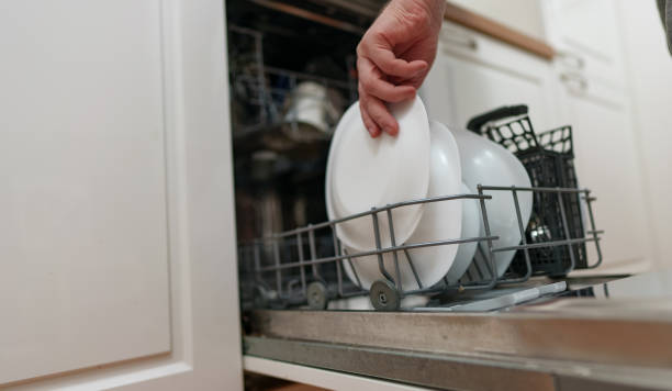 istock Man takes a plate from the dishwasher. 1302868094