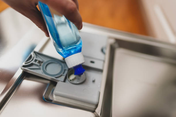 istock Man pours rinse aid into the dishwasher compartment. 1302868105