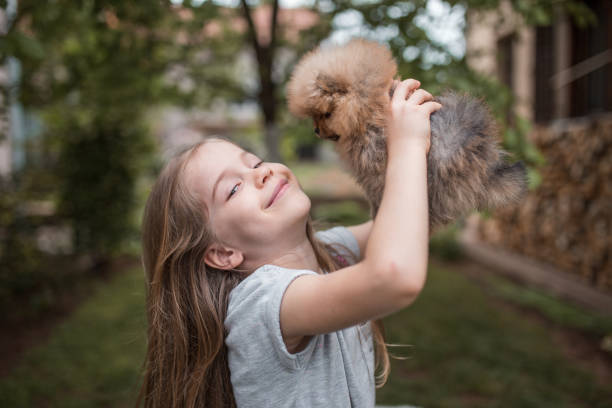 istock Smiling girl playing with little dog 1302868797