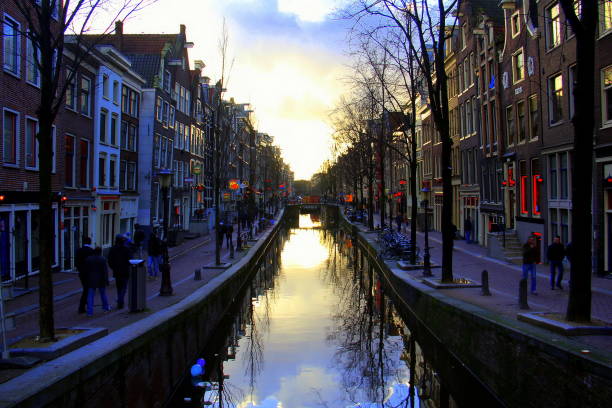 Canal and townhouses in the historic heart of the city, De Wallen, red-lights district, winter evening view, Amsterdam, Netherlands Canal and townhouses in the historic heart of the city, De Wallen, red-lights district, winter evening view, Amsterdam, Netherlands wellen stock pictures, royalty-free photos & images