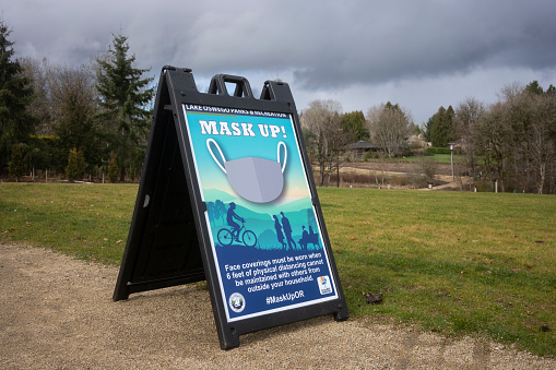 Lake Oswego, OR, USA - Feb 7, 2021: Mask Up sign is seen on the trails in the newly-opened Woodmont Park in Lake Oswego, Oregon, amid the coronavirus pandemic.