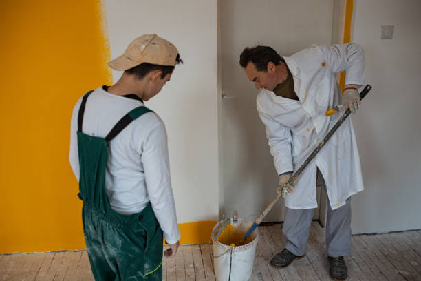 istock Son helping father to paint the walls 1302875776