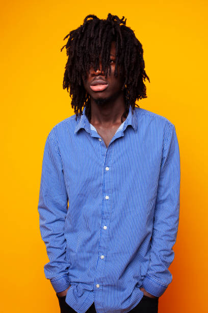 istock young handsome african american guy student posing cheerful and gesturing on yellow background, lifestyle people concept 1302875981