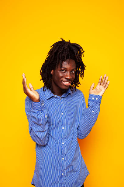 istock young handsome african american guy student posing cheerful and gesturing on yellow background, lifestyle people concept 1302876002