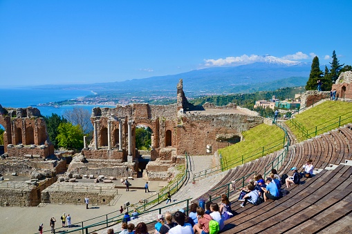 Taormina, Sicily 04/18/2016 The ancient Greco Roman theatre in Taormina is still used for performances today with incredible hilltop views of the Ionian Sea and Mount Etna