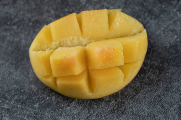 istock Slice of yellow mango on the grey marble 1302883876