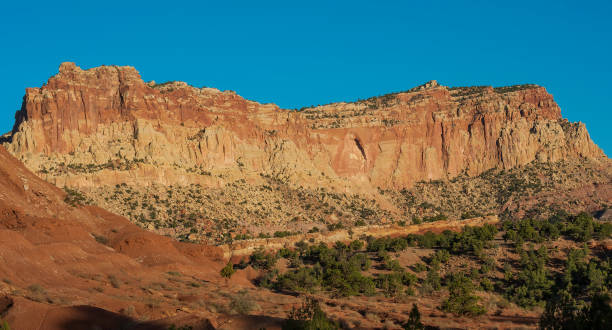 On the Scenic Drive in Capitol Reef National Park. From the top down Wingate Sandstone, Chinle Formation, and Moenkopi Formation layers from the Jurassic and Triassic Periods. Capitol Reef National Park, Utah; Part of the Waterpocket Fold. Colorado Plateau area uplifted to create the Waterpocket Fold. en el scenic drive en el parque nacional capitol reef. desde la parte superior hacia abajo wingate sandstone, chinle formation, y moenkopi formation capas de los períodos jurásico y triásico. parque nacional capitol reef, utah; parte del waterpocket fol