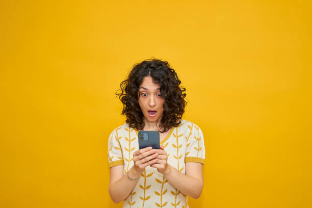 istock Young woman looks surprised while texting 1302889080