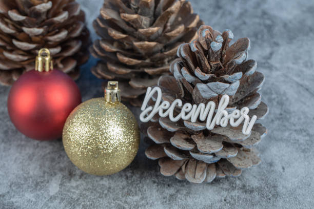 istock Christmas tree cone with december writing on it and glittering figures around 1302890172