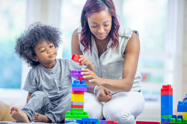 istock Preschool teacher and student building a tower together 1302891450