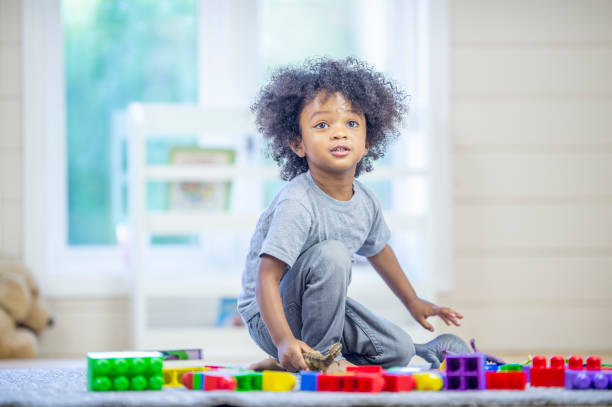istock Cute preschool boy playing with colourful blocks 1302891454