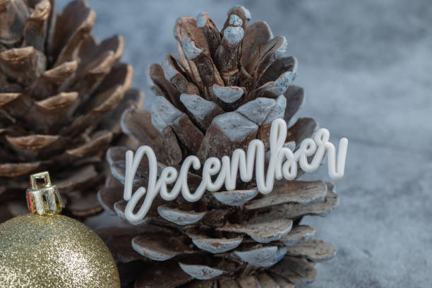 istock Christmas tree cone with december writing on it and glittering figures around 1302892690