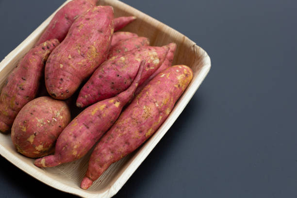 istock Sweet potato on dark background. Top view 1302893773