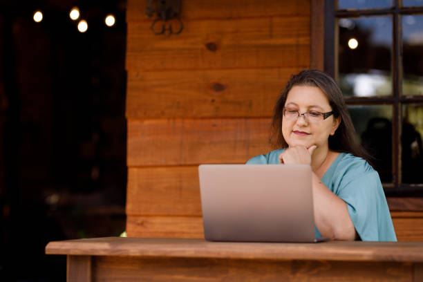 istock Woman working on laptop at cabin outside 1302894443