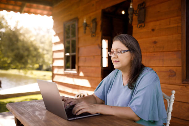 istock Woman working on laptop at cabin outside 1302894456