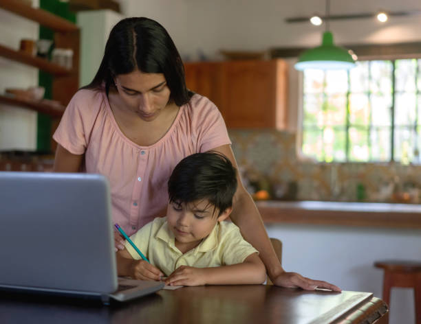 istock Mother helping her son with his homeschooling using a laptop computer 1302894560