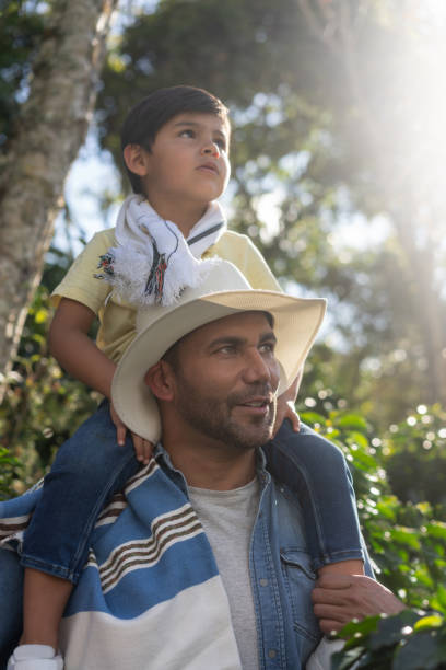 istock Colombian coffee farmer teaching his son about the plantation 1302894646