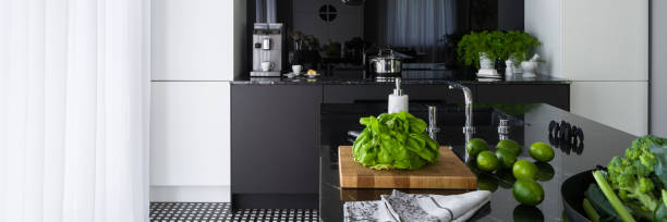 istock Black and white kitchen with island, panorama 1302896807