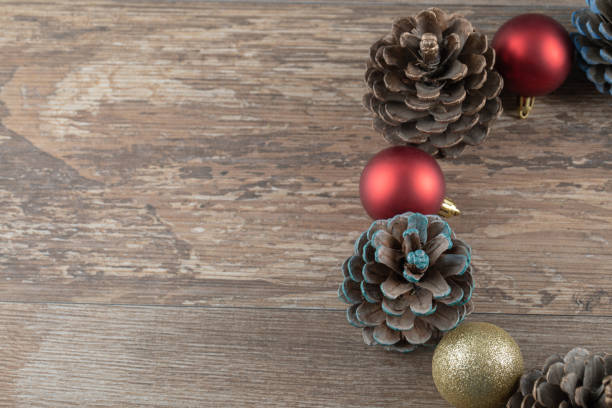 Natural oak tree cones on a wooden deck with glittering ornaments around. High quality photo