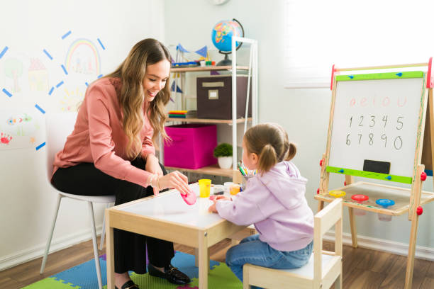istock Therapist using clay to play with a preschooler during child therapy 1302900764
