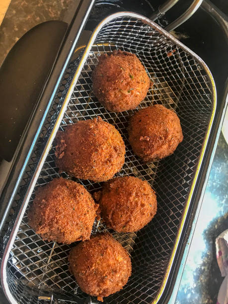 Six Fried boudin balls in silver fryer basket stock photo
