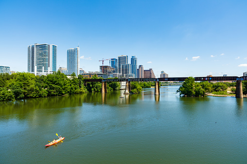 Austin, Texas USA - April 14, 2016: Skyline view of the downtown area along the Colorado River with kayakers cruising by.