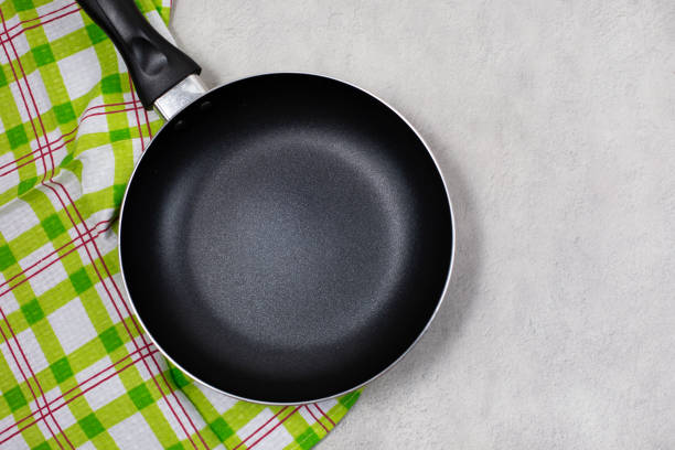 istock Empty black frying pan with green kitchen towel 1302911192
