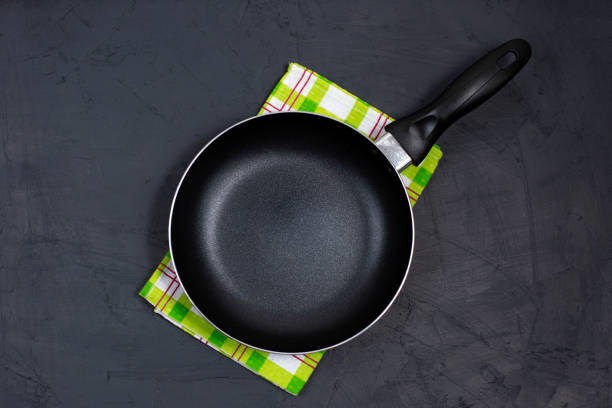 istock Empty black frying pan with green kitchen towel 1302911193