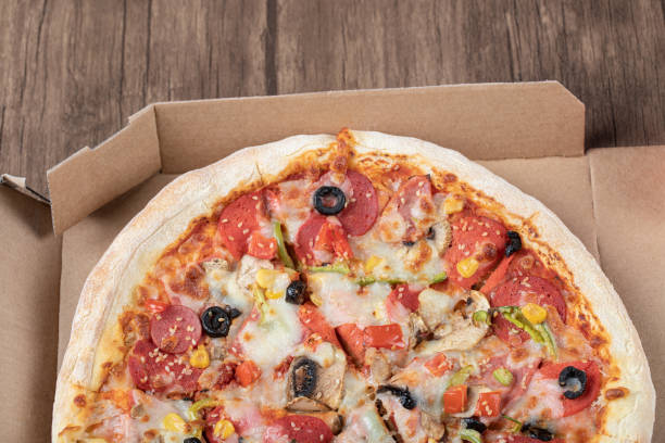 istock Pepperoni pizza with black olives in a cardboard takeaway box 1302911909