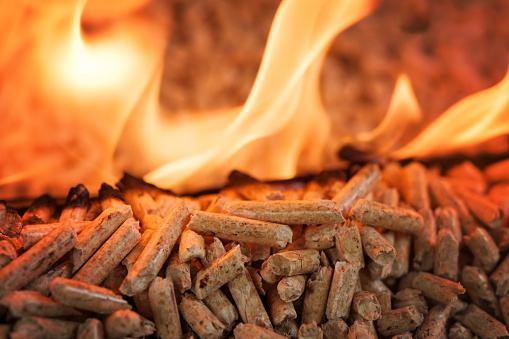 Closeup of Pile of coniferous pellets in flames - wooden biomass