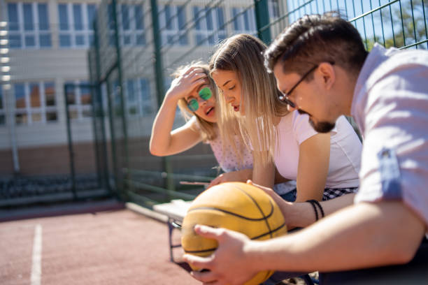 istock Friends using digital tablet on basketball court 1302917381