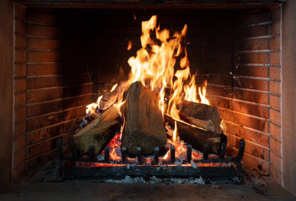 brennender kamin, echte holzstämme, gemütliches warmes haus zur weihnachtszeit - house burning color image danger stock-fotos und bilder